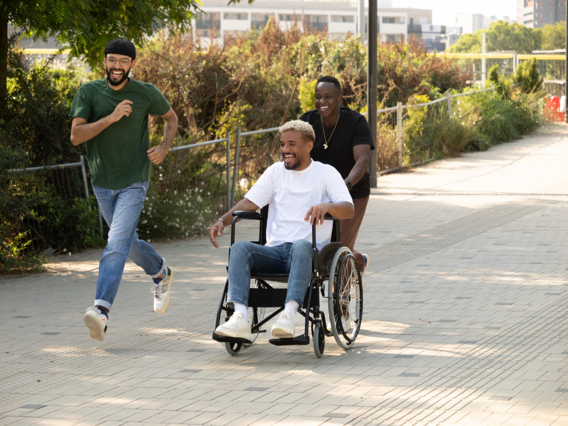 three-diverse-male-friends-one-of-them-in-a-wheelc-2024-01-23-18-50-03-utc